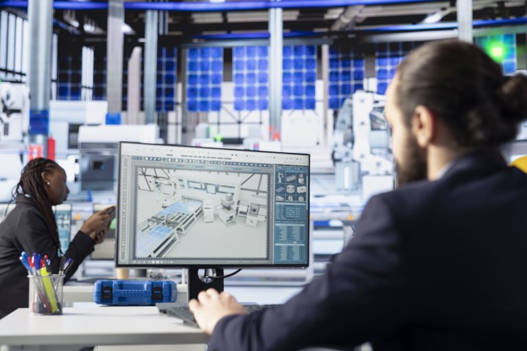 Solar panels plant engineer looking over assembly lines blueprints on PC screen